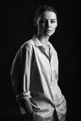 A beautiful red-haired girl with freckles in a shirt posing in the studio . grain effect used