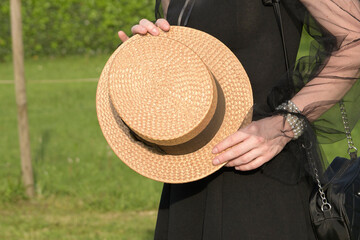 Authentic Straw Hat 20s - 30s. A hat from the last century in the hands of a woman in nature.