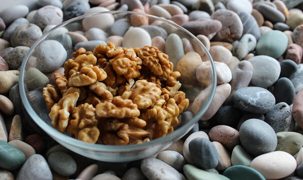 Healthy Food And Nutrition Stock Photo. Walnut Kernels In A Dessert Bowl On Smooth Rocks On The Side Of Image 
