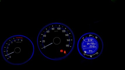 A closer view of a car odometer or speedometer with its glowing lights