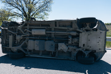 Road traffic accident. Overturned car on the highway. Severe damage to the vehicle. Close-up,...