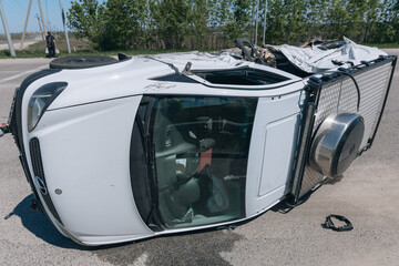Road traffic accident. Overturned car on the highway. Severe damage to the vehicle. Close-up,...