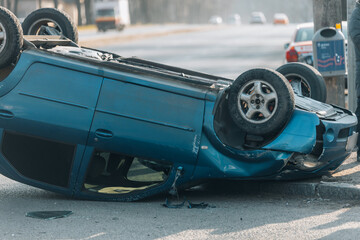 Road traffic accident. Overturned car on the highway. Severe damage to the vehicle. Close-up,...