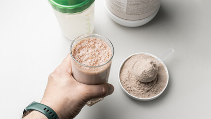 Male hand holding a protein drink cocktail in a glass