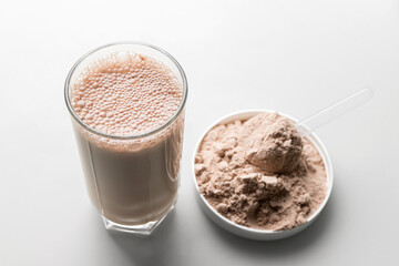 Protein drink cocktail in a glass and whey protein powder in a measuring scoop