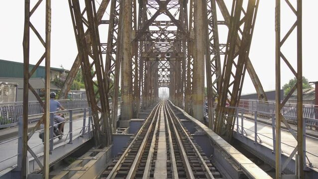 Vintage steel train bridge at Long Bien railway through a river in Downtown Hanoi, Vietnam. Urban city town.