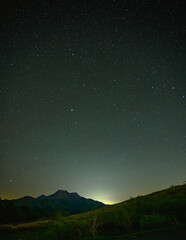 澄んだ夜空に広がる満天の星と石鎚山のシルエット