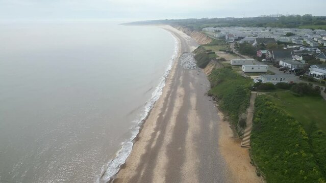 Forward drone view of historic Pakefield Beach during evening in Lowestoft, England. Aerial shot.