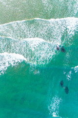 waves on the shore of a beach, turquoise sea water. Top view with drone