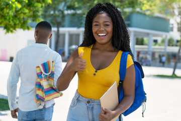 Successful black female student showing thumb up