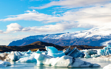 A large body of water is covered in ice, with mountains in the background