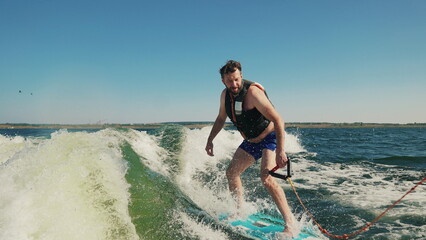 A man wakeboards after a boat. Fun on the water during the hot summer on the lake. Wakeboarding....