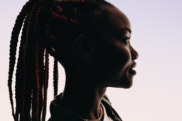 Silhouette of a young woman with braids in closeup headshot on white background