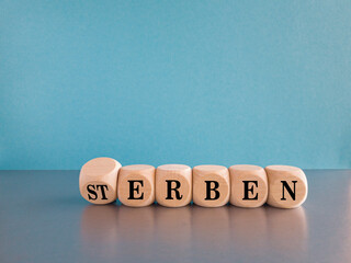 Turned dice and changes the German word 'Sterben' (die) to 'erben' (inherit). Beautiful grey table,...