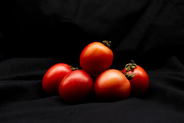 Tomato on black background. Still-life food with concept of black and red, fresh vegan, healthy...
