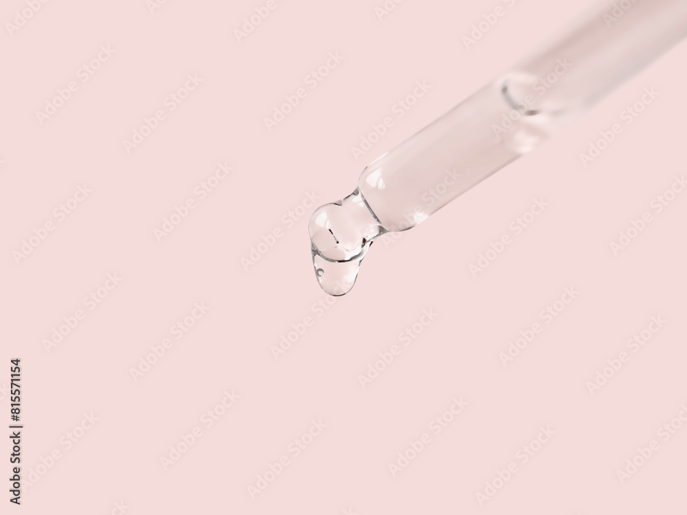 Wall mural glass pipette filled with cosmetic serum close-up isolated on pink background