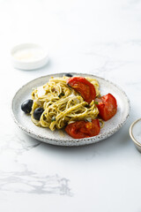 Spaghetti with pesto, tomatoes and olives