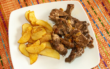 Plato de carne de conejo de caza frito acompañado de patatas fritas. Receta española de carne de...