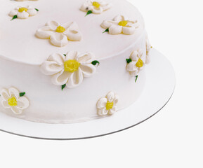 White fondant cake adorned with sugar daisies on a clean background