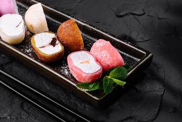 Assorted mochi ice cream on dark slate background