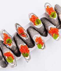 Elegant sushi set with red caviar and basil