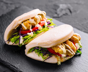 Delicious gourmet chicken bao sandwiches on slate