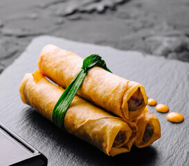 Fresh spring rolls on slate with dipping sauce