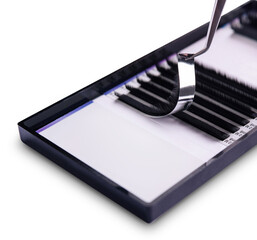 Close-up image of tweezers holding an eyelash extension above a tray