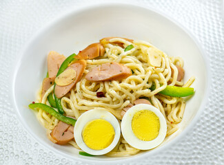 A plate of pasta with sausage, peppers, and eggs.