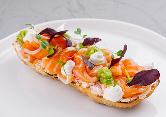 Gourmet smoked salmon bruschetta on white plate