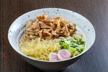 A bowl of udon noodles with pork and tempura