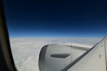 passenger view from an airplan at cruising altitude on a cloudy day