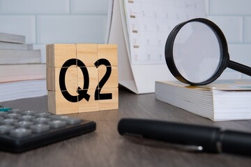 Close up image of wooden cubes with alphabet Q2 on office desk. Second quarter concept.