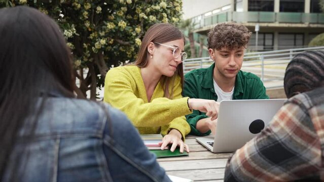 Students using laptop working and learning together discussing about University project. Blond girl with eyeglasses