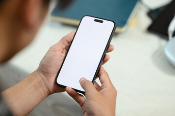 Close up man holding smartphone with empty screen lying on couch at home