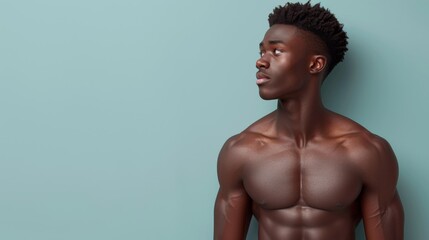 Fototapeta premium A portrait of a young, muscular man stretching, showcasing strength and fitness against a teal background.