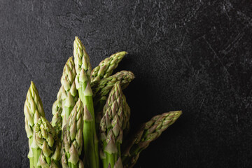 Green asparagus on a black background with copy space