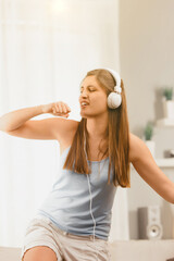 Fototapeta premium Woman dances joyfully, headphones on, music flowing