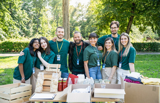 Portrait of a group of volunteers in uniform during a food bank charity event, donating basic necessities for the needy