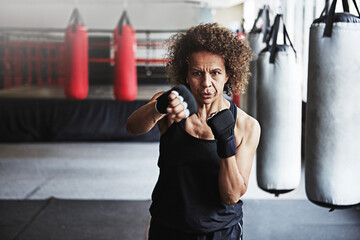 Fitness, punching and mature woman in gym for exercise, boxing challenge or competition training....