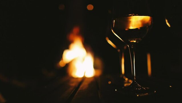 Reflection of wineglasses in a row with fireplace in the background