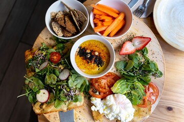 Wooden table presented with several plates of food arranged on it