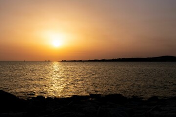 Beautiful landscape of a lake with a glowing orange sunset in the background