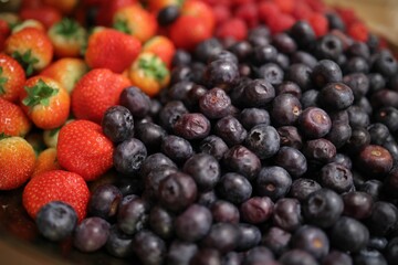 Array of blueberries and strawberries on a wooden table