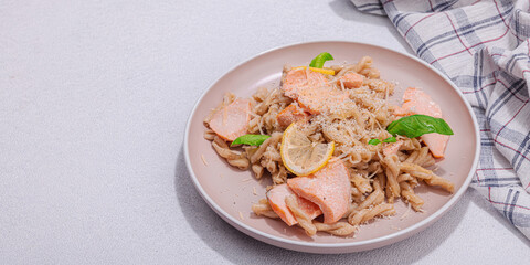 Plant based pasta with salmon, pesto and parmesan cheese. Ready to eat healthy food, served portion
