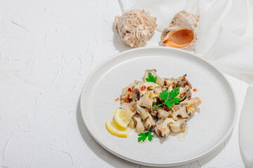 Rapana clam meat with oil, spices and greens. Healthy seafood is rich in omega. Marine decor