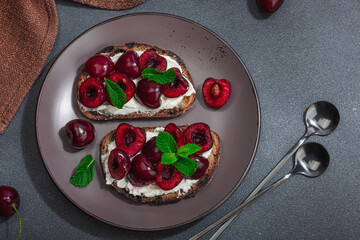 Fresh bread sandwiches with sweet cherry, cream cheese and mint leaves. Morning breakfast concept