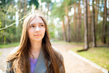 Portrait of a beautiful teenage girl, young woman with long hair in the park	