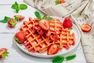 Homemade Belgian Waffles with strawberries. Gluten-free red dessert, fresh fruits and basil