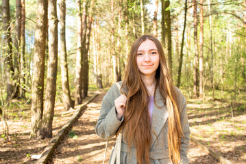 Portrait of a beautiful teenage girl, young woman with long hair in the park	